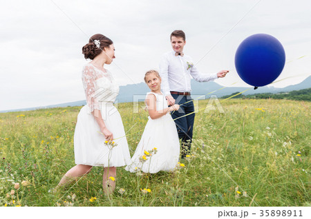 A young couple and their daughter in wedding 35898911