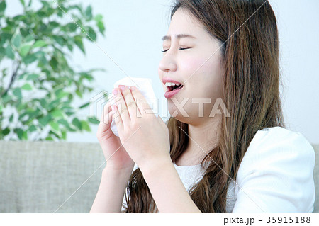 くしゃみをする女性の写真素材