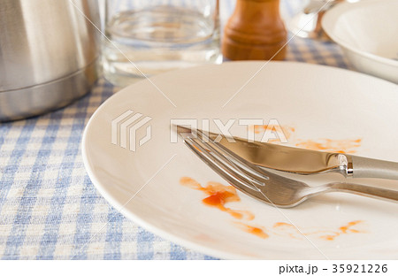 皿 カトラリー 完食 チェック柄 ナイフ フォーク 汚れ ソース タレ の写真素材