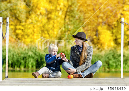 Blond boy with his mother sitting on the dock Blond boy with his mother sitting on the dock 35928459