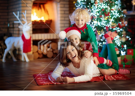 Family with kids at Christmas tree and fireplace. Family with kids at Christmas tree and fireplace. 35969504