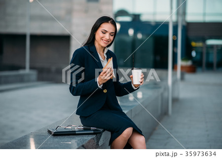 Happy business woman with sandwich and coffee 35973634