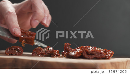 closeup man slicing sundried tomatoes 35974206