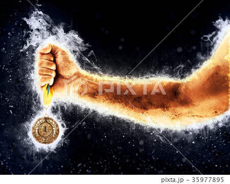 Man's hand in a blue fire is holding gold medal 35977895