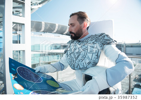 Concentrated astronaut reading space map Concentrated astronaut reading space map 35987352