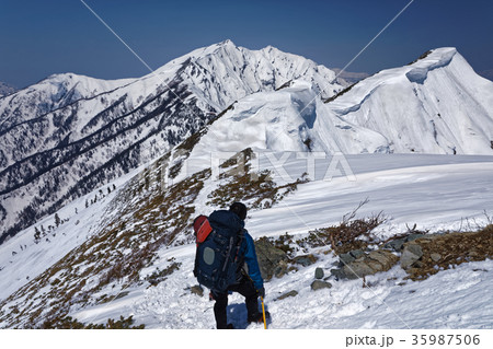 残雪の爺ヶ岳稜線の登山者と鹿島槍ヶ岳 35987506