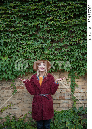 Excited blond girl observing clamberer on wall Excited blond girl observing clamberer on wall 35987760
