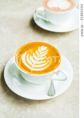White cup with latte coffee and cake White cup with latte coffee and cake 35993504