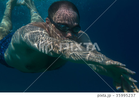 Tourist man in swimming sports glasses swimming Tourist man in swimming sports glasses swimming 35995237