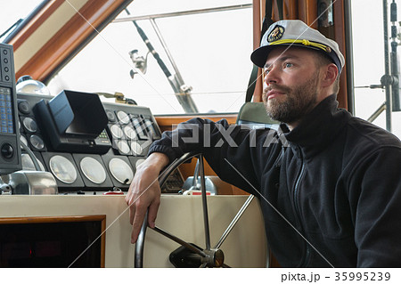 Captain at the helm of boat going along the Captain at the helm of boat going along the 35995239