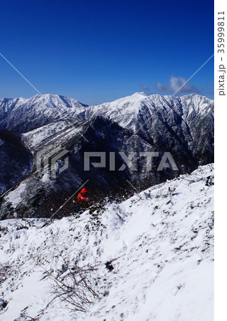 大雪山東大雪のユニ石狩岳山頂付近を登る登山者と石狩岳・音更山 35999811
