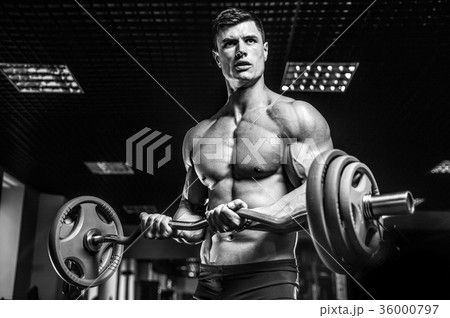 Handsome model young man training arms in gym 36000797