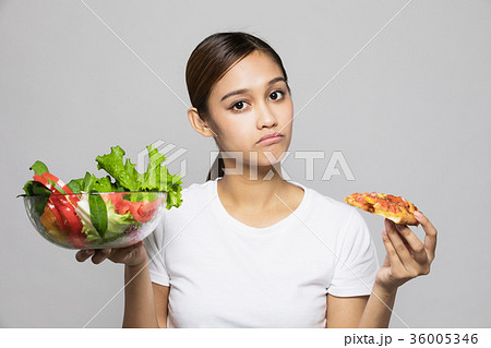 サラダとピザを持つ女性の写真素材