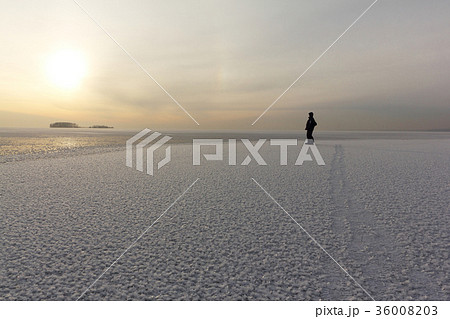 Man standing on ice of a freezing pond Man standing on ice of a freezing pond 36008203