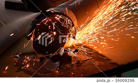 Cutting metal with disc grinder with bright sparks 36008206