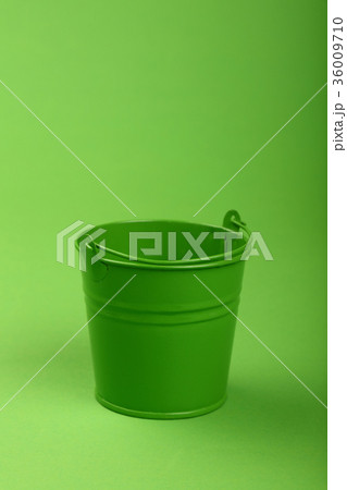 Small metal bucket on green background close up Small metal bucket on green background close up 36009710