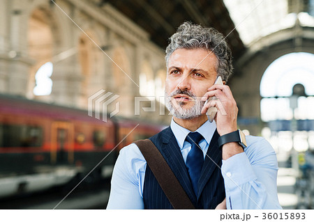 Mature businessman with smartphone on a train Mature businessman with smartphone on a train 36015893