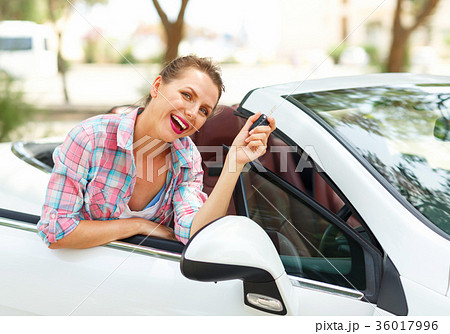 Woman is standing near car with the keys in hand Woman is standing near car with the keys in hand 36017996