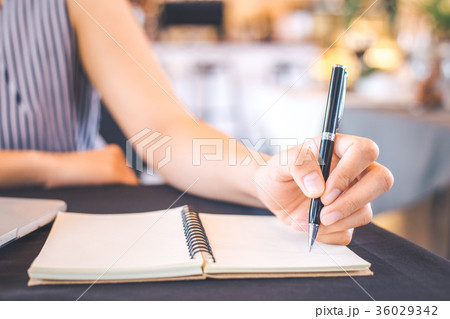 Woman hand writing on notepad with a pen. Woman hand writing on notepad with a pen. 36029342