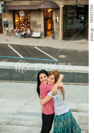 Two sisters hugging in the street Two sisters hugging in the street 36032706