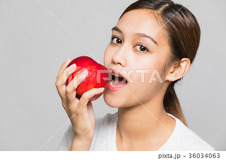 りんごをかじる女性の写真素材