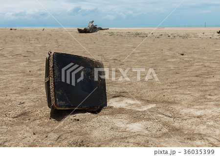 The old television remains were left on the beach. The old television remains were left on the beach. 36035399