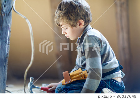 Little kid boy helping with toy tools on Little kid boy helping with toy tools on 36037649