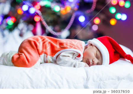 One week old newborn baby in Santa hat near One week old newborn baby in Santa hat near 36037650