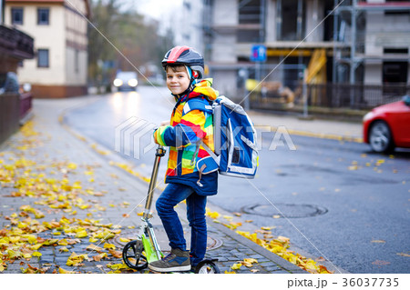 Cute little kid boy riding on scooter on way to Cute little kid boy riding on scooter on way to 36037735