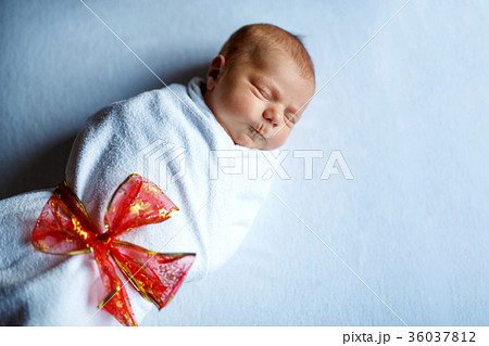 One week old newborn baby sleeping wrapped in One week old newborn baby sleeping wrapped in 36037812