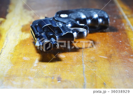 revolver gun on wooden table 36038929