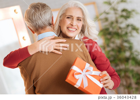 Radiant lady grinning broadly and hugging her Radiant lady grinning broadly and hugging her 36043428