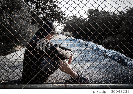 Depressed man wearing hoodie sitting on the ground Depressed man wearing hoodie sitting on the ground 36048235
