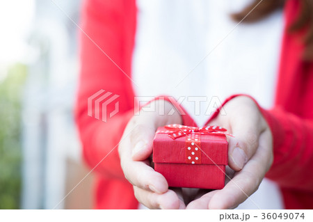 woman holding gift box. asian female wear white shirt and red knitting cardigan with present box. christmas, new year, birthday, valentine, celebration concept. woman holding gift box. asian female wear white shirt and red knitting cardigan with present box. christmas, new year, birthday, valentine, celebration concept. 36049074
