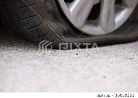 Car tire leak because of nail pounding. flat tyre on road. Flatten punctured wheel 36050353