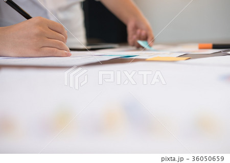 young successful startup team on meeting in office. businessman & businesswoman brainstorm, make a business plan, work on tablet with financial and marketing graph and chart 36050659