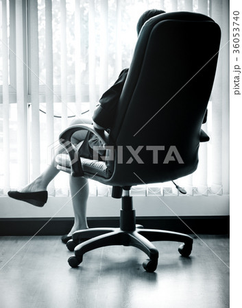 businesswoman sitting on a Armchair looking out businesswoman sitting on a Armchair looking out 36053740
