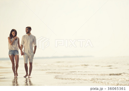 Happy fun beach vacations couple walking together Happy fun beach vacations couple walking together 36065361