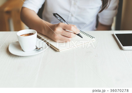 Woman writing in the notebook. 36070278