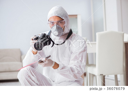 Forensic expert at crime scene doing investigation 36076079