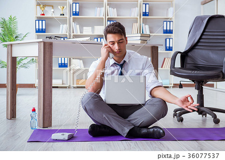 Man meditating in the office to cope with stress 36077537