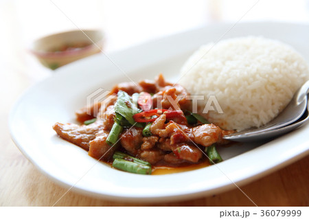 fried pork with thai curry and rice on wood background , Thai food 36079999