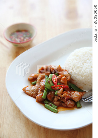 fried pork with thai curry and rice on wood background , Thai food 36080060