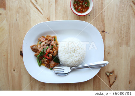 fried pork with thai curry and rice on wood background , Thai food 36080701
