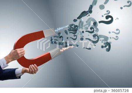 Businessman catching questions on horseshoe magnet 36085726