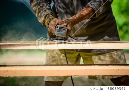 Worker is scrubbing wood plank . 36089341