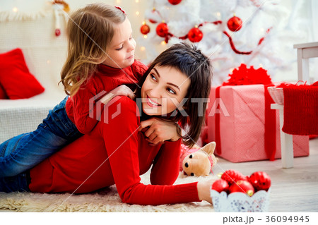 Cheerful woman with daughter in Christmas time Cheerful woman with daughter in Christmas time 36094945