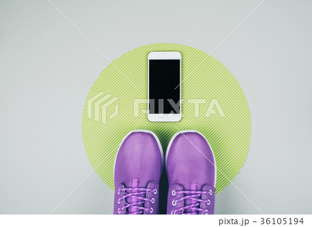 Sneakers and phone on gray background. Sneakers and phone on gray background. 36105194