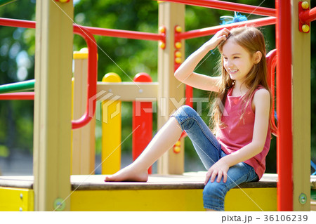 Cute little girl having fun on a playground outdoors 36106239