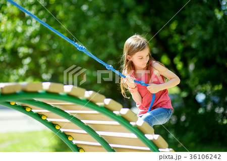 Cute little girl having fun on a playground outdoors 36106242